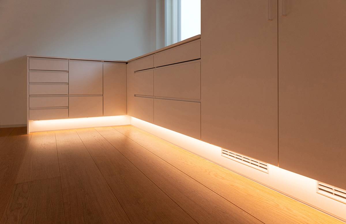 Una luz en el zócalo de la cocina que ilumina el suelo.