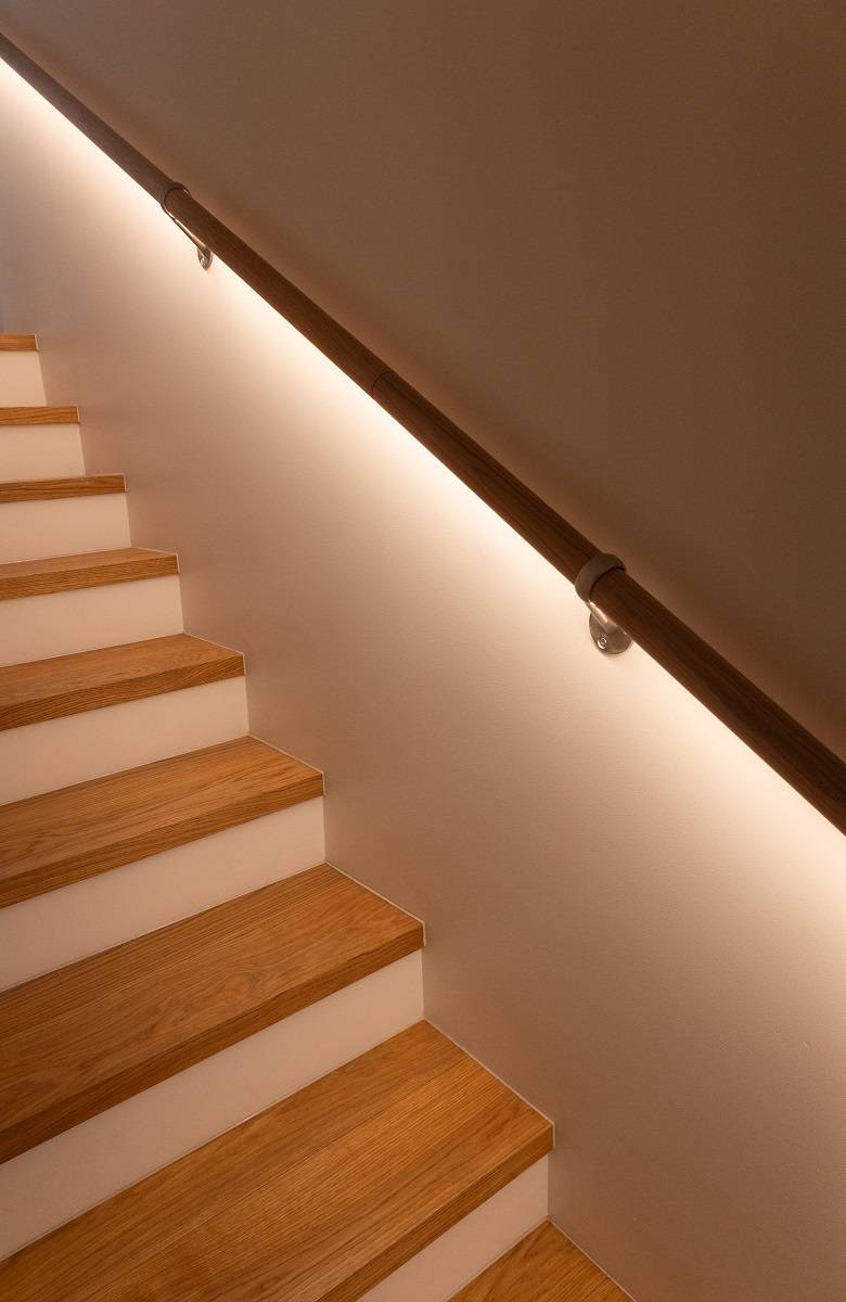 En las escaleras, se ve un destello de luz por debajo de la barandilla.