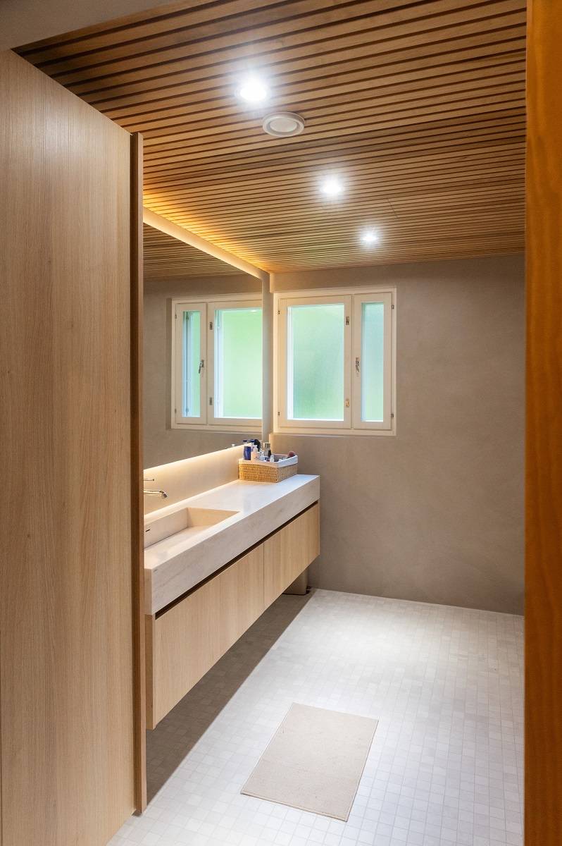 Focos empotrados en el techo del baño y una tira de luces LED detrás del espejo.