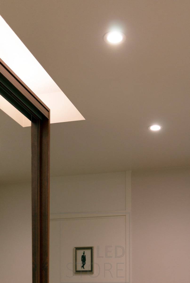 Encima del armario de puertas correderas del pasillo, una tira de LED en perfil de superficie blanco y 7,2 W/m con CCT atmosférico ilumina el techo. LedStore.fi