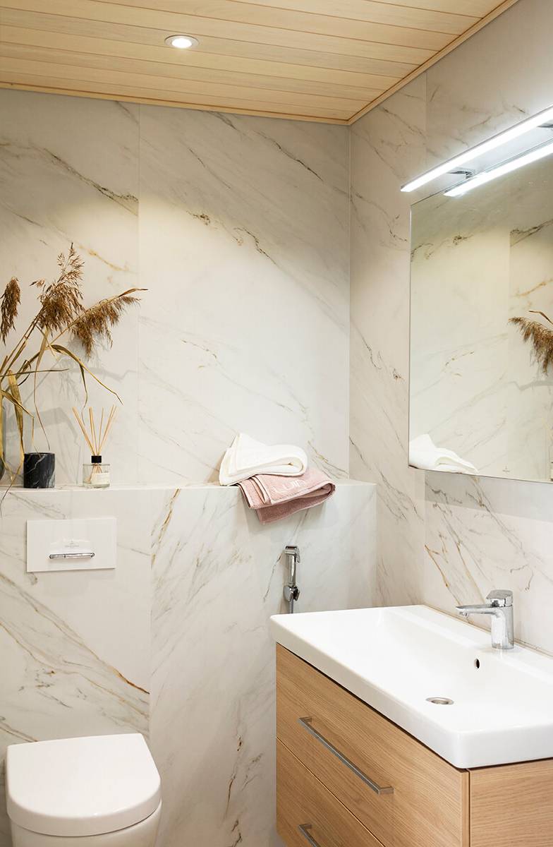 Foco en el techo del cuarto de baño. Colocar el foco cerca de la pared acentúa su patrón de luz. Ledstore.fi