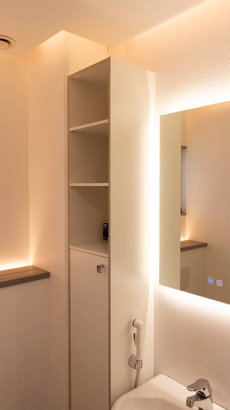 Luz indirecta en el baño. Un espejo luminoso combinado con luz indirecta procedente del techo y una tira de LED ascendente detrás de la mampara del inodoro. Ledstore.fi