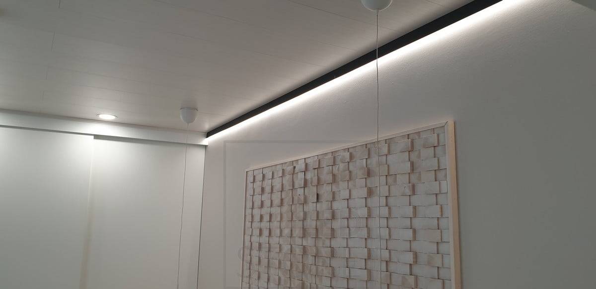 En el dormitorio, un perfil de pared negro sustituye a la moldura del techo, con una tira de LED en el perfil que ilumina la pared para crear una luz ambiental indirecta. Ledstore.fi