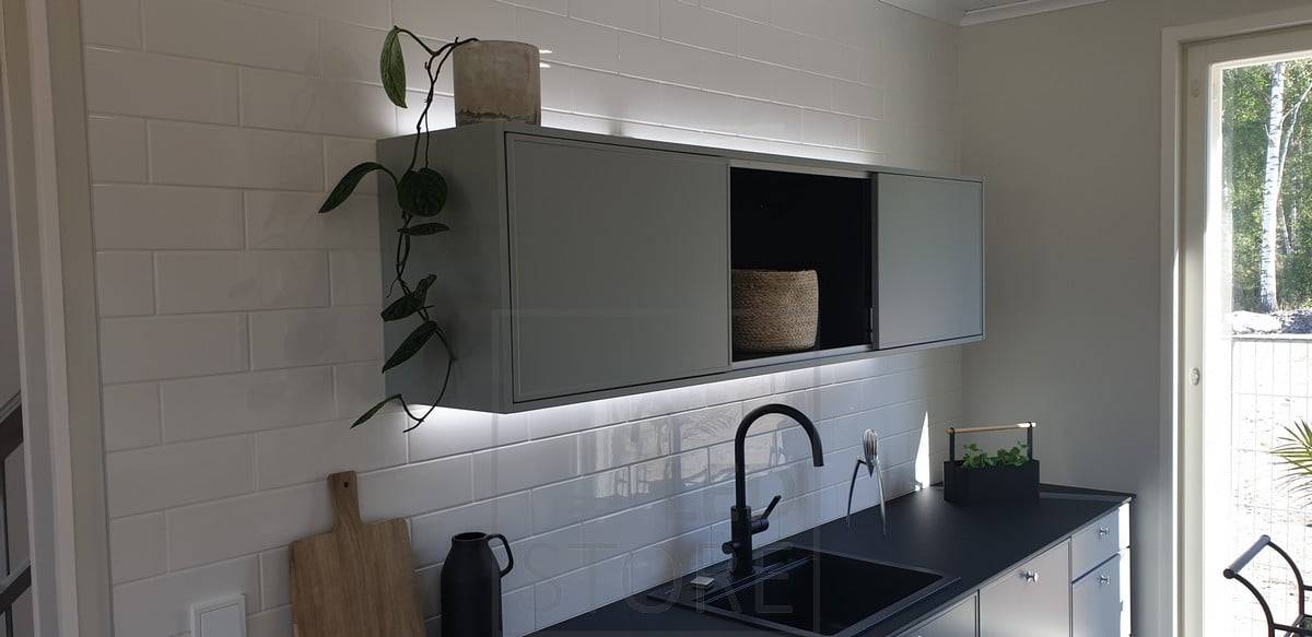 Las tiras de LED iluminan la parte superior del armario y la encimera, creando un bonito efecto de luz que acentúa la cocina. Ledstore.fi
