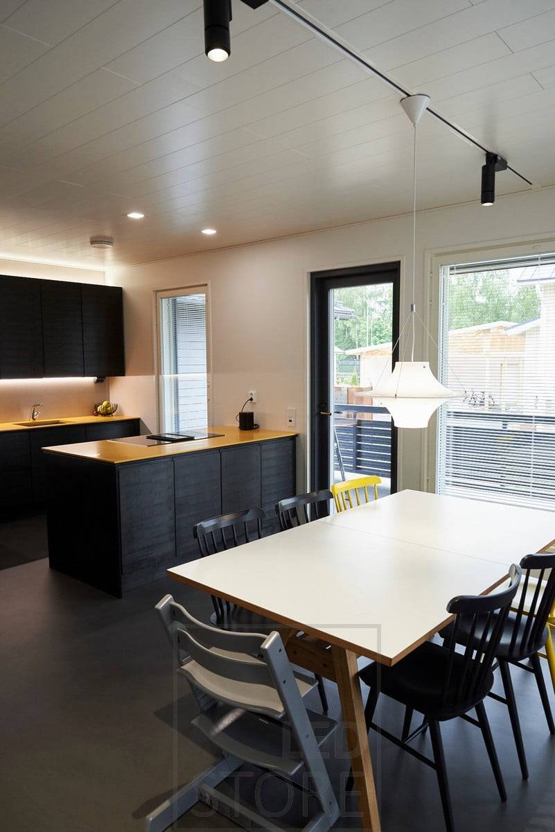 Iluminación de riel en el comedor. En la cocina, iluminación indirecta por encima de los armarios e iluminación de la encimera en la parte inferior de los armarios superiores iluminando el espacio intermedio. Ledstore.fi