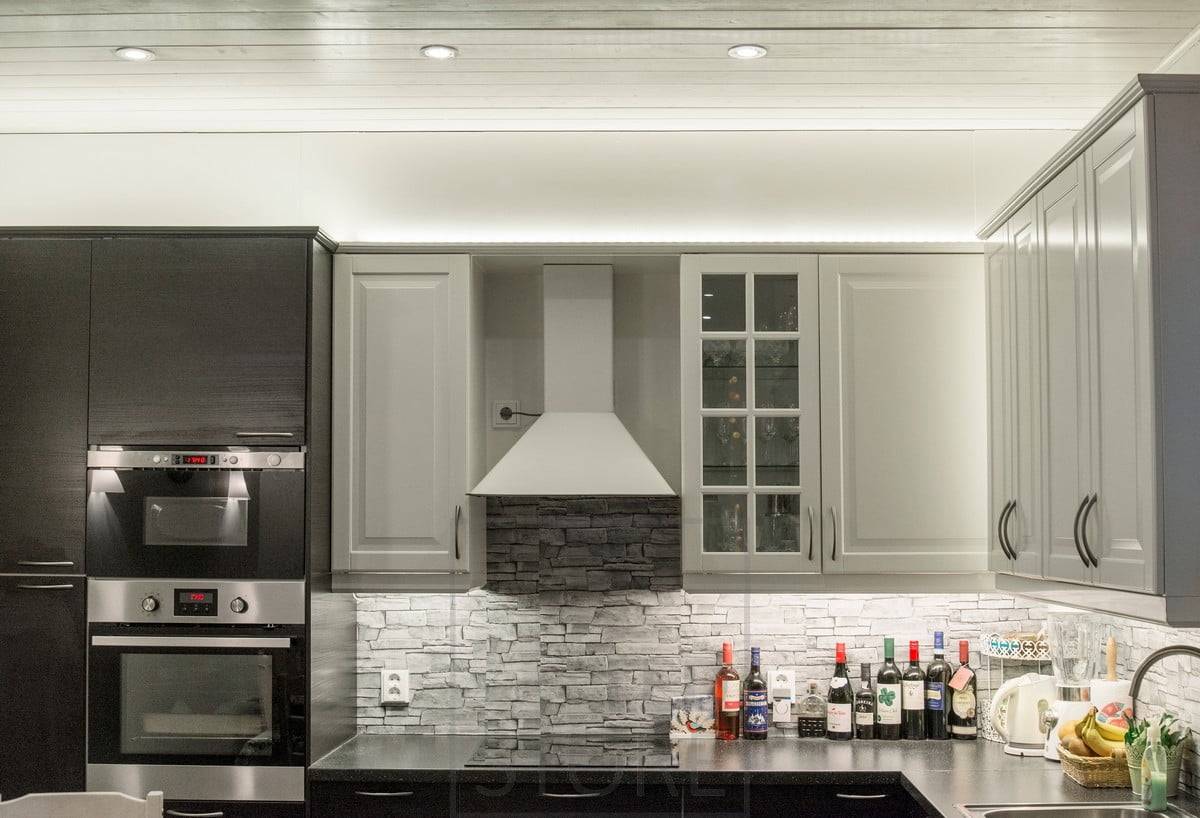 En la cocina, encima de los armarios, tiras de leds iluminan indirectamente hacia arriba, la luz se abre a través del techo. Focos como iluminación general. El nivel se ilumina con una tira de leds fijada a la parte inferior de los armarios superiores. Ledstore.fi