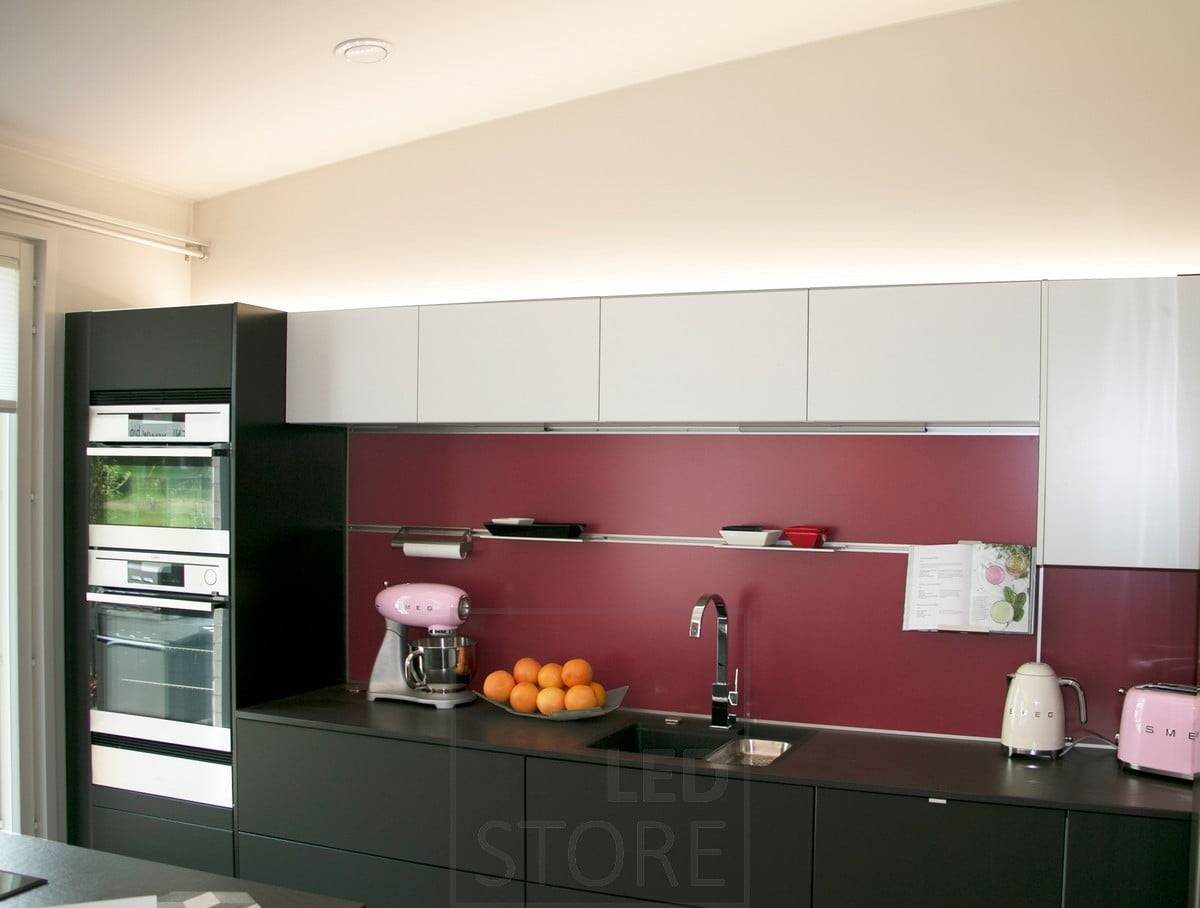 Una tira de leds encima de los armarios iluminando la cocina con luz indirecta. Ledstore.fi