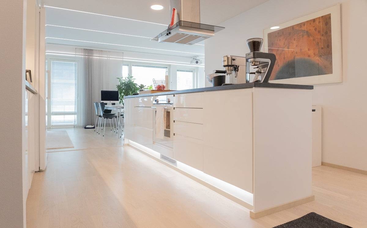 Tira de LED iluminando el zócalo de una isla de cocina como iluminación de acento. ©LedStore