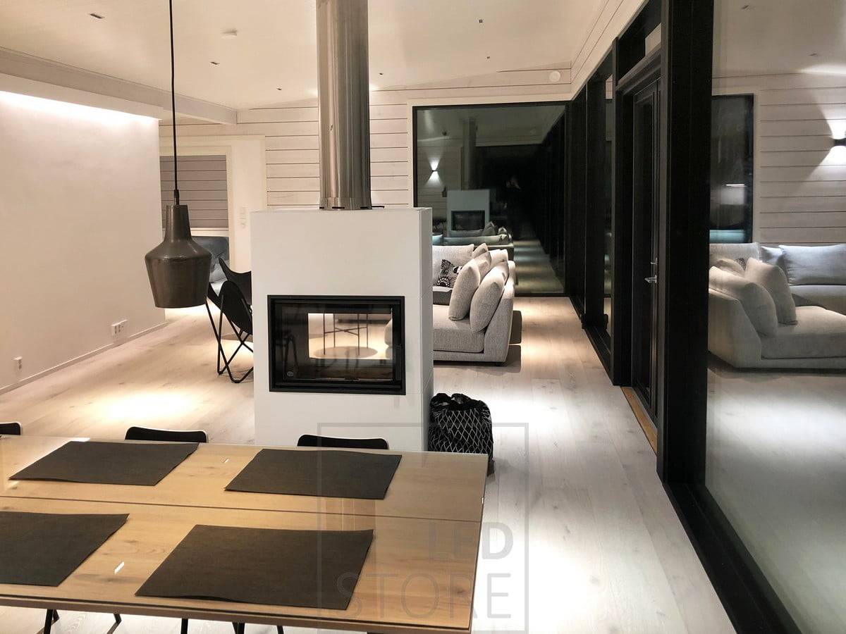 Iluminación atmosférica y versátil. Una tira de LED detrás del techo ilumina el espacio indirectamente, focos LINJA en el techo y un aplique FUNK en la pared. Lámparas colgantes sobre la mesa del comedor. Ledstore.fi