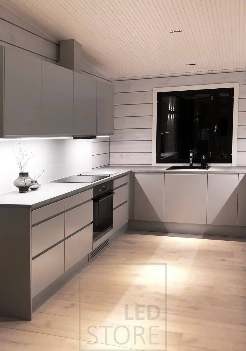 Iluminación de la cocina - tiras de LED en perfiles de aluminio en la parte inferior de los armarios superiores de la cocina iluminando las encimeras y focos LINJA en el techo. Ledstore.fi