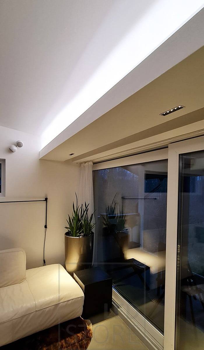 Iluminación ambiental del salón con tira de LED para luz indirecta y 5 focos LINJA para luz de ángulo estrecho hacia abajo. Ledstore.fi