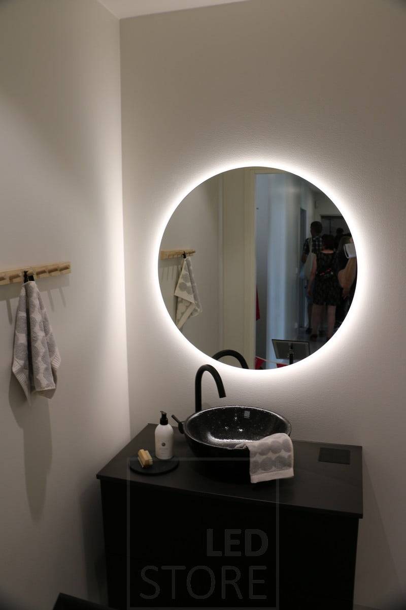 El espejo con luz led MOON tiene un marco de cristal de leche de 3 cm de ancho, detrás del cual una tira led protegida contra la humedad proporciona una iluminación sin deslumbramientos tanto hacia el espectador como en forma de reflejo en la superficie de la pared a su alrededor. Ledstore.fi