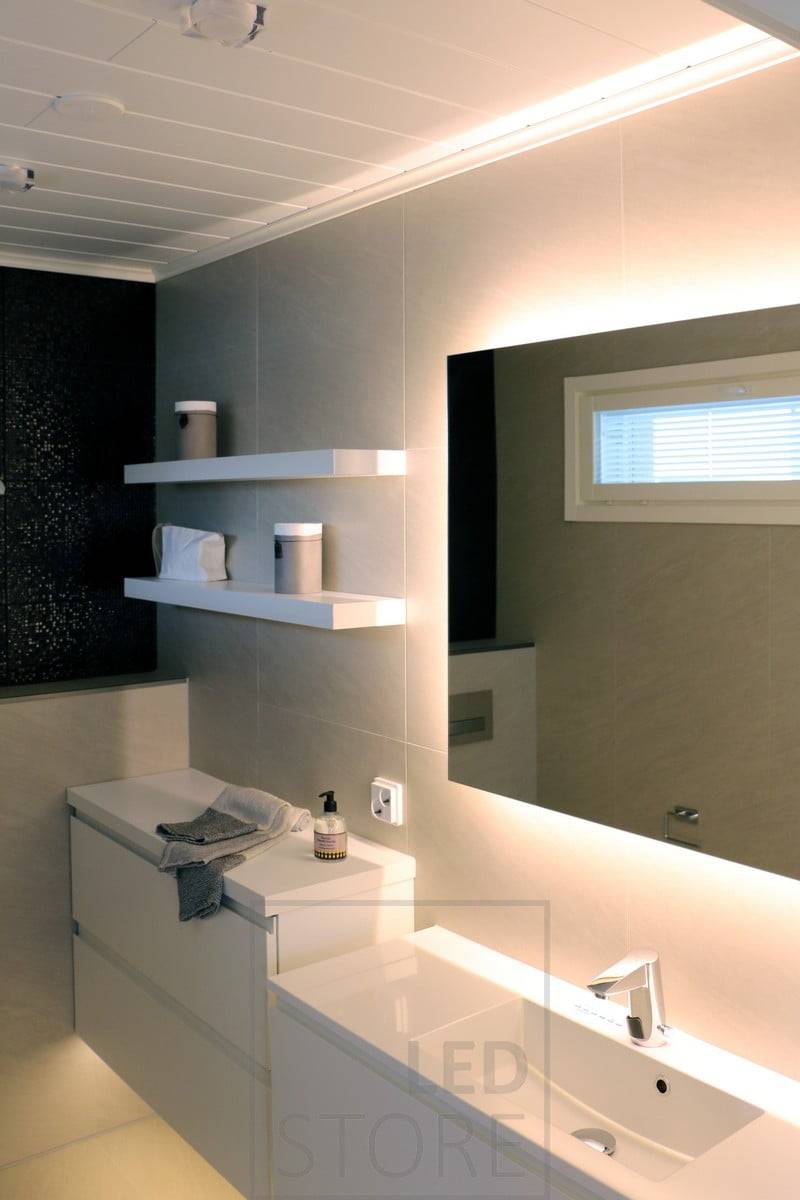 Iluminación suave y ambiental en el cuarto de baño con un espejo luminoso y una tira de luz LED bajo el nivel del suelo. Ledstore.fi