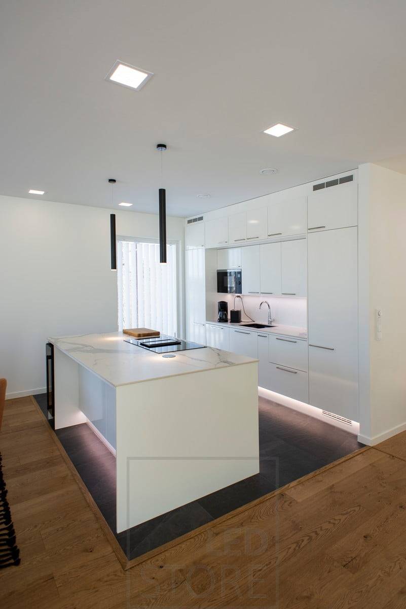 Iluminación versátil y de alta calidad en la cocina. Paneles de leds como iluminación general, lámparas colgantes de chimenea sobre la isla y tiras de leds en zócalos y sobre la encimera. Ledstore.fi