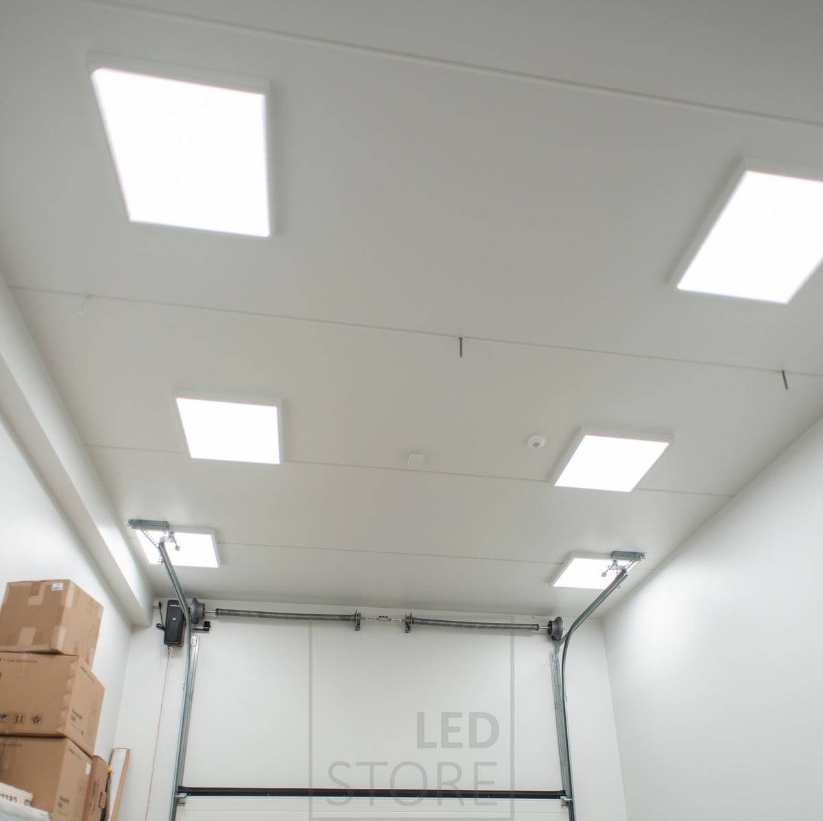 Paneles de 600x600 en marcos de superficie en el techo de un almacén. La iluminación es adaptable y eficiente, sin rincones oscuros en el espacio. Ledstore.fi