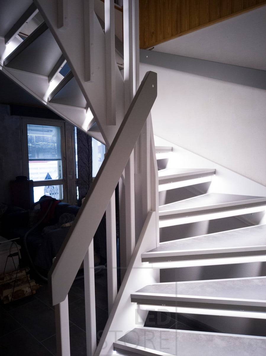 Tiras de leds en los peldaños iluminando la escalera con luz indirecta. La iluminación es suave y atmosférica. Ledstore.fi