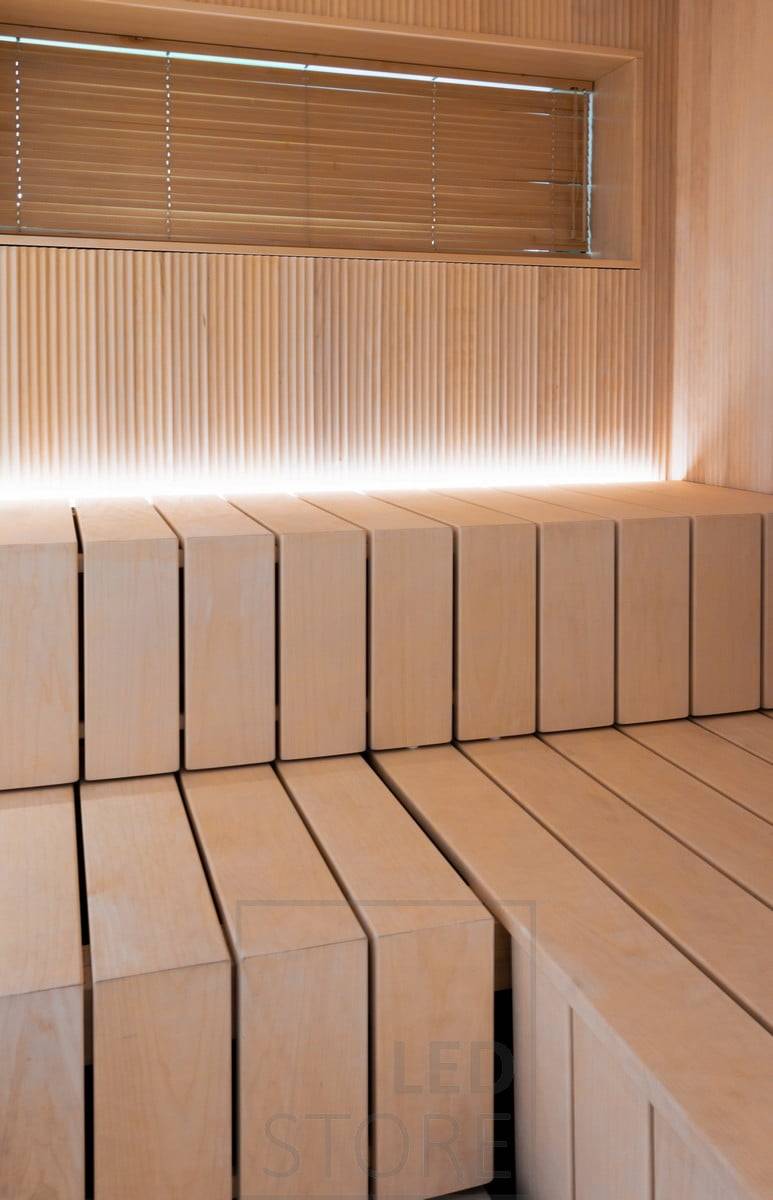En la sauna, una tira de luz led en la ranura detrás del banco, orientada hacia arriba. Ledstore.fi