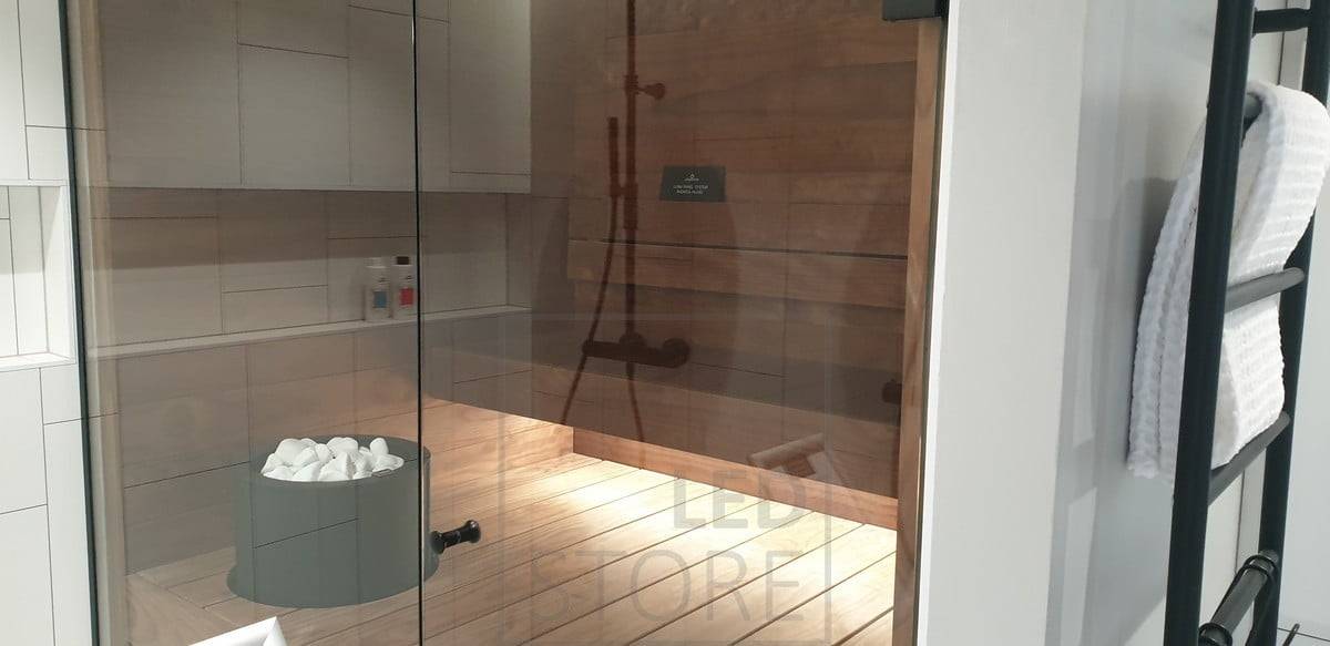 Cinta de leds bajo la condensación, ilumina la sauna con luz indirecta. La iluminación del lavabo también se extiende a la sauna gracias a la pared de cristal. Ledstore.fi
