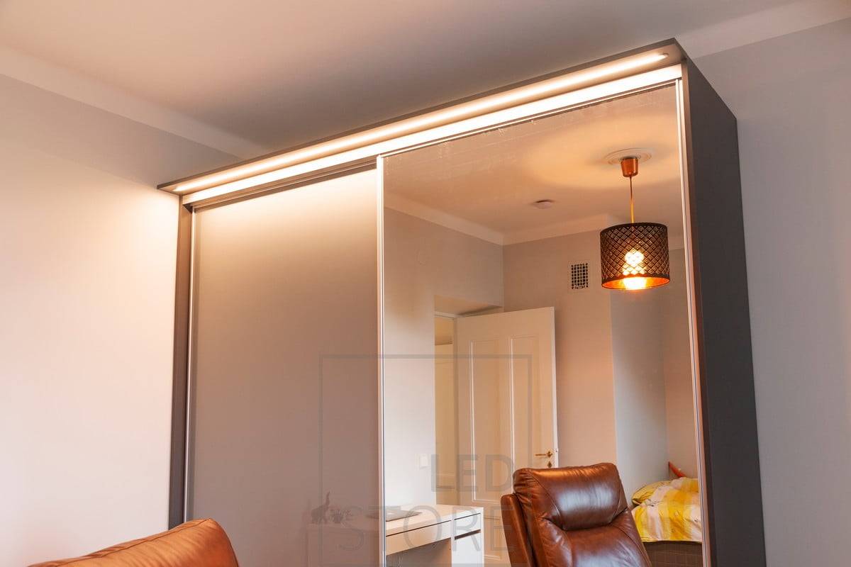 Tira de leds en un estrecho perfil enrasado que ilumina la caja superior de un armario. La luz ilumina el espacio a su alrededor, el espejo, así como el interior del armario. Ledstore.fi