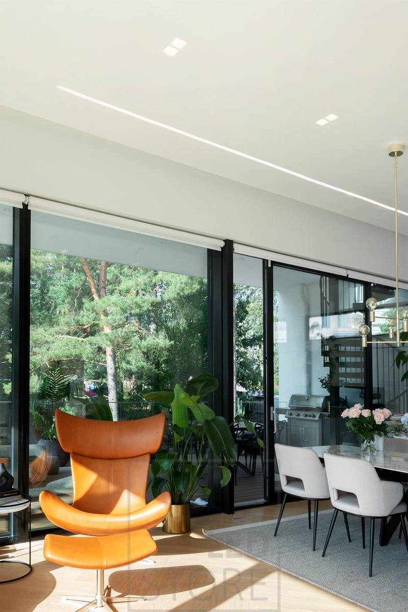 Un amplio perfil empotrado en el salón y la cocina abierta crea una hermosa línea de luz bien iluminada junto a la ventana. Ledstore.fi