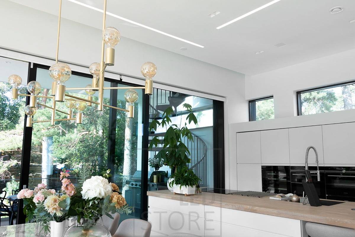 Los perfiles anchos empotrados en el salón y la cocina abierta crean líneas de luz bonitas y bien iluminadas. Ledstore.fi