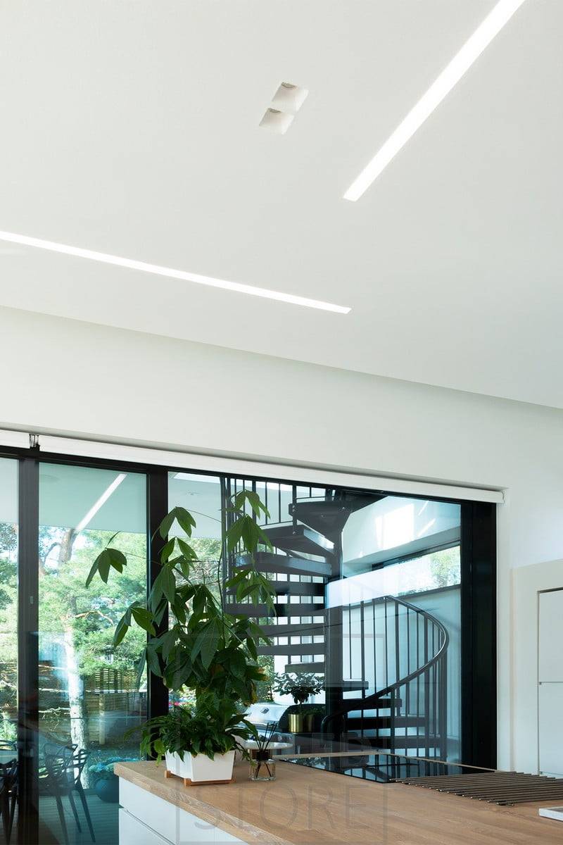 Amplios perfiles empotrados en el salón y la cocina abierta crean líneas de luz bellas y bien iluminadas. Perfiles Uppo combinados con focos empotrados minimalistas. Ledstore.fi