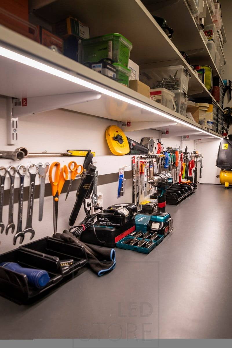 Tira de leds en la parte inferior de una estantería para iluminar un puesto de trabajo en un almacén. Ledstore.fi