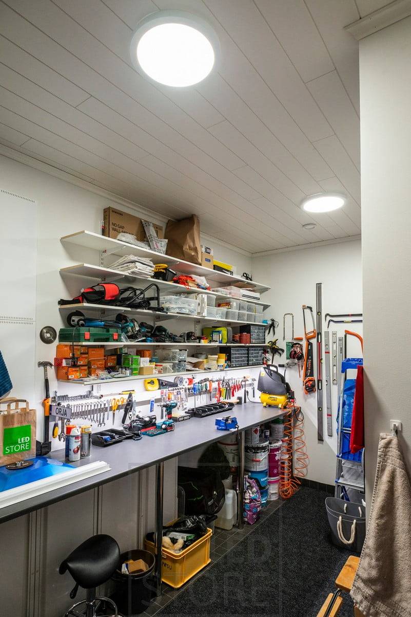 Puesto de trabajo en un almacén con grandes lámparas colgantes en el techo. Ledstore.fi