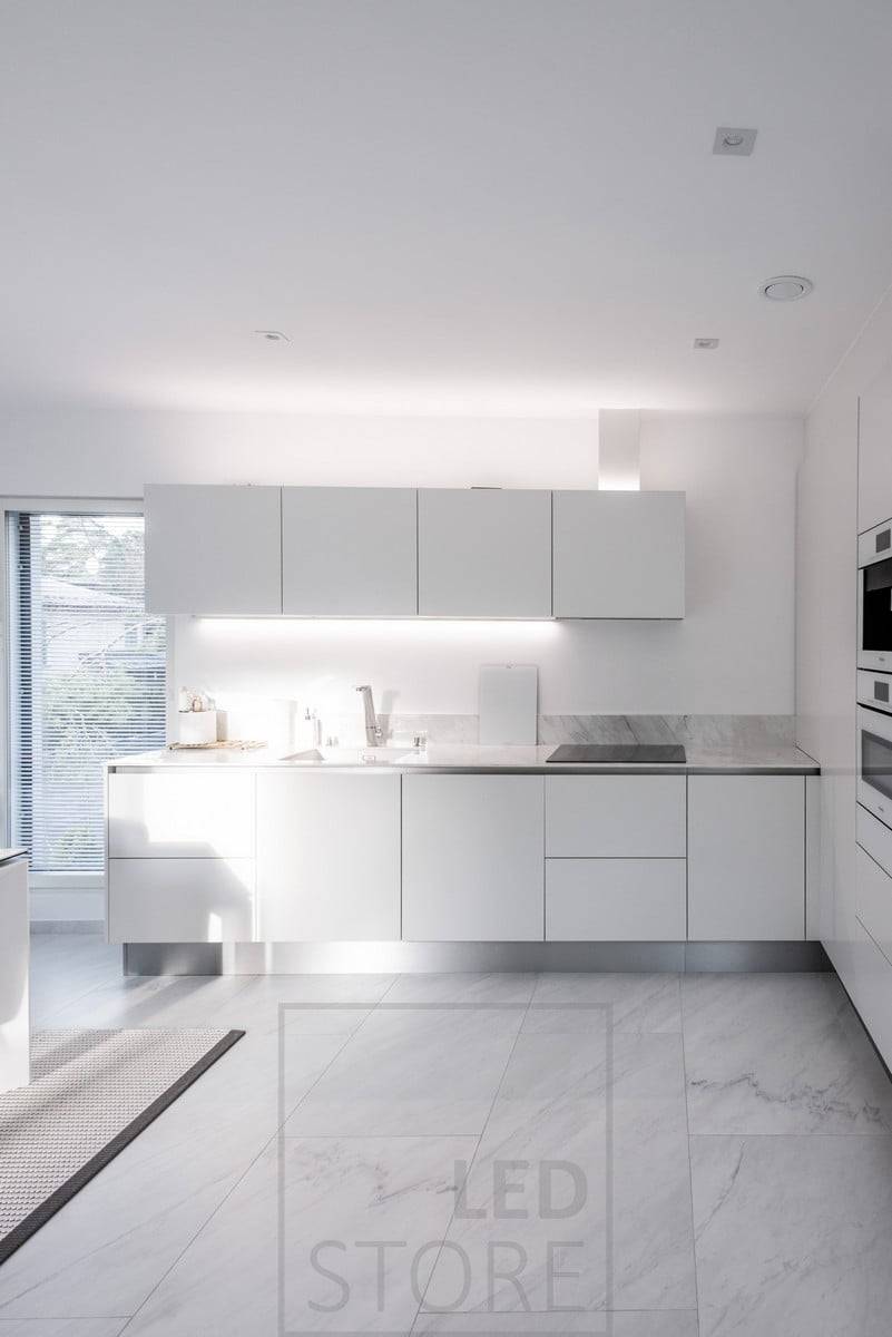 En la cocina, un perfil led montado en la parte inferior de un armario y otro perfil led que proporciona luz indirecta en la parte superior de los armarios. Ledstore.fi