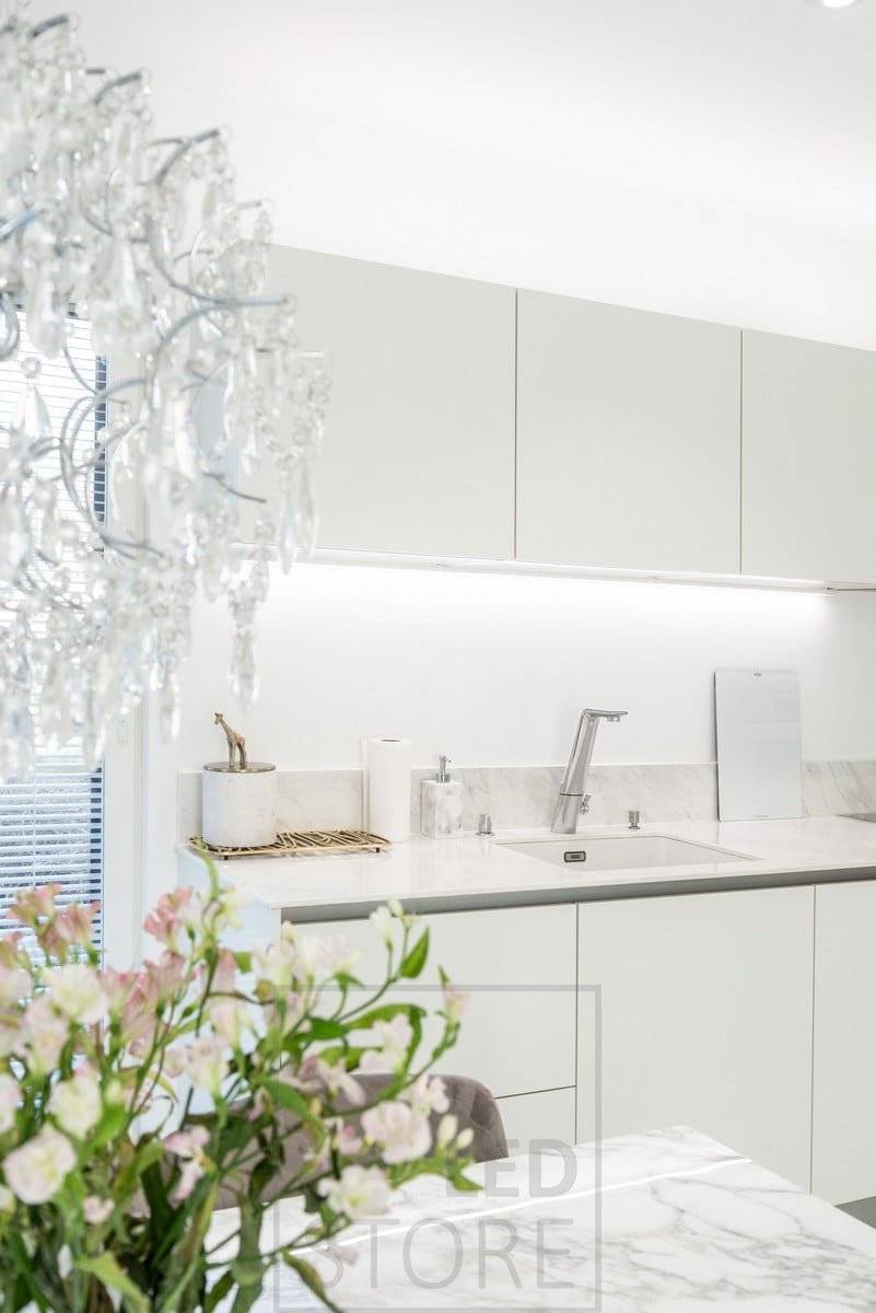 Cocina iluminada con tiras led debajo y encima del armario superior. Ledstore.fi