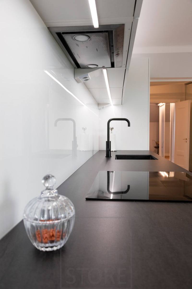 En el centro de los armarios superiores, una tira de LED de perfil bajo ilumina la encimera de la cocina. Ledstore.fi