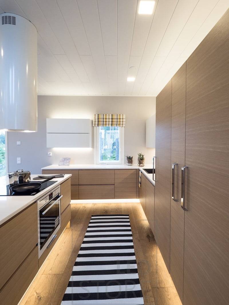 En la cocina, tiras de luces LED en el zócalo, encima de los armarios y en la encimera. Ledstore.fi