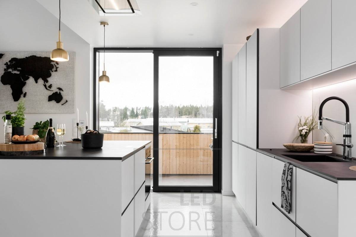 En la cocina, la parte inferior de los armarios superiores y la parte superior de los armarios se iluminan con tiras de LED. Ledstore.fi