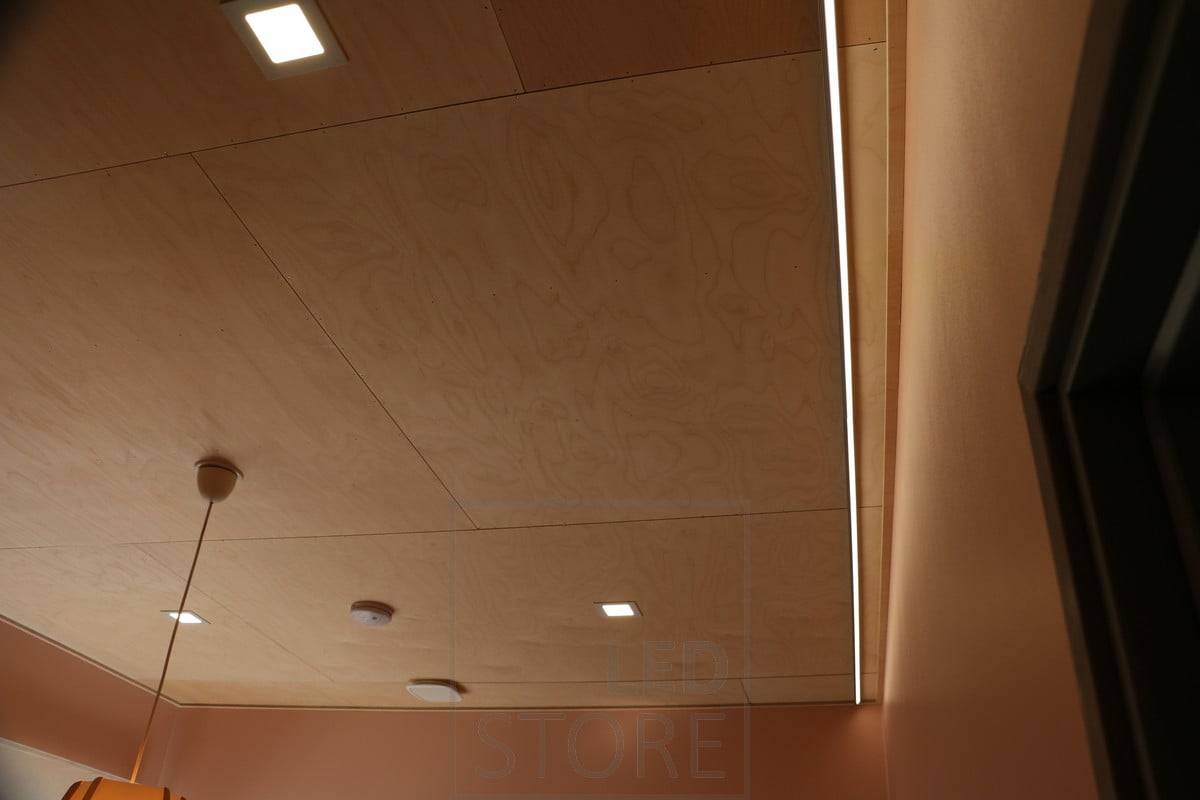 Paneles de luz y luz indirecta en el salón, con un plafón decorativo en el centro de la habitación. Ledstore.fi