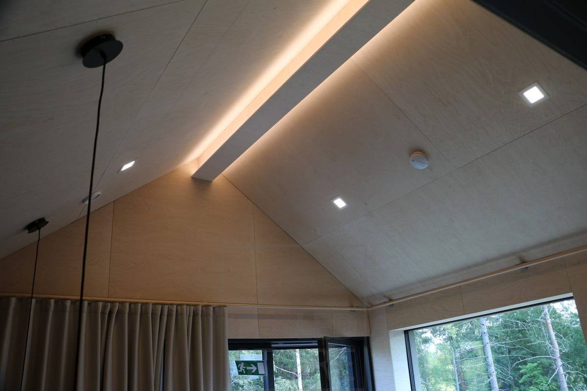 Tira de leds en un techo inclinado para acentuar el patrón del techo y crear una iluminación ambiental. La iluminación general corre a cargo de paneles luminosos adicionales. Ledstore.fi