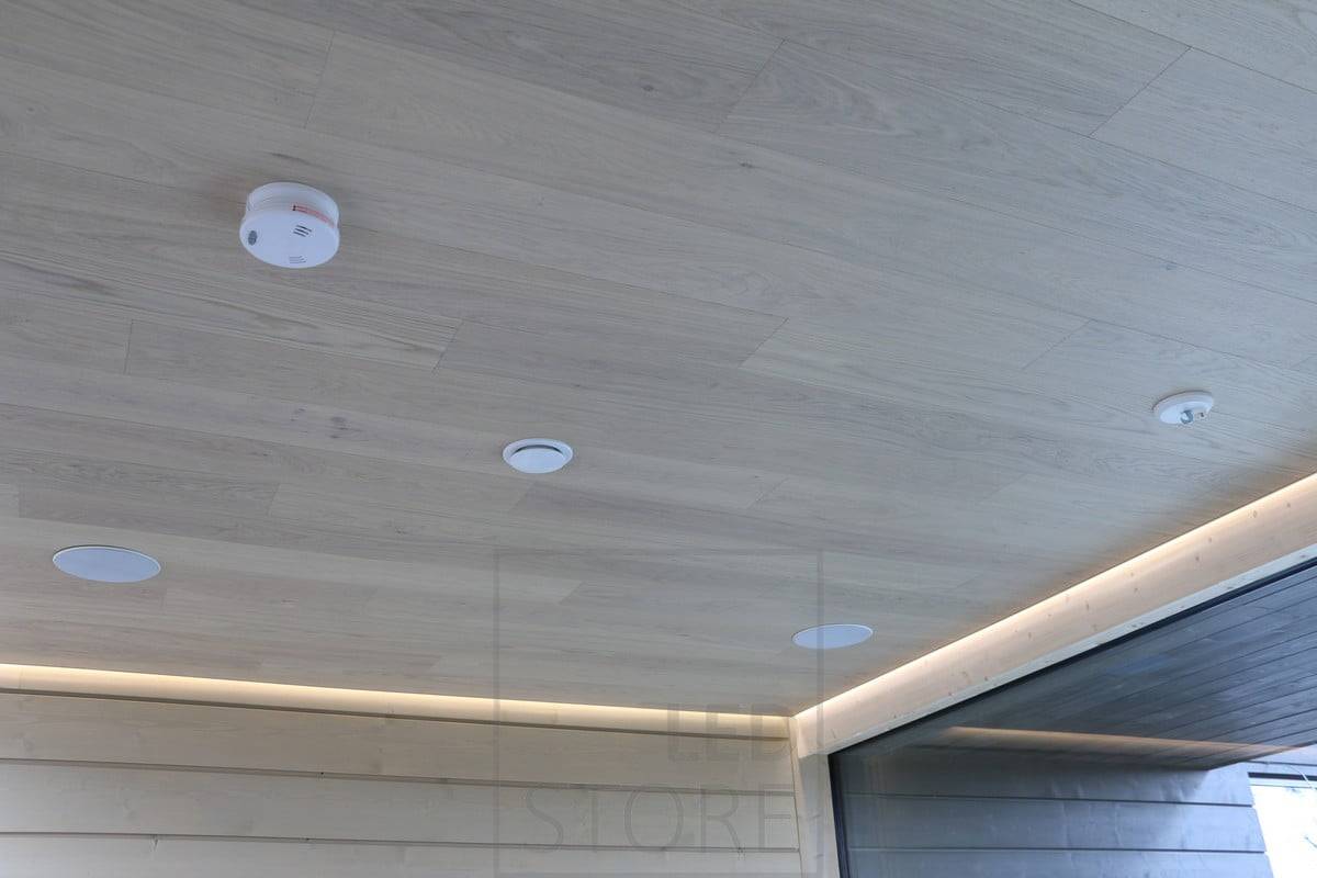 Entre el techo y la pared, una tira de leds ilumina el salón con luz indirecta. Ledstore.fi