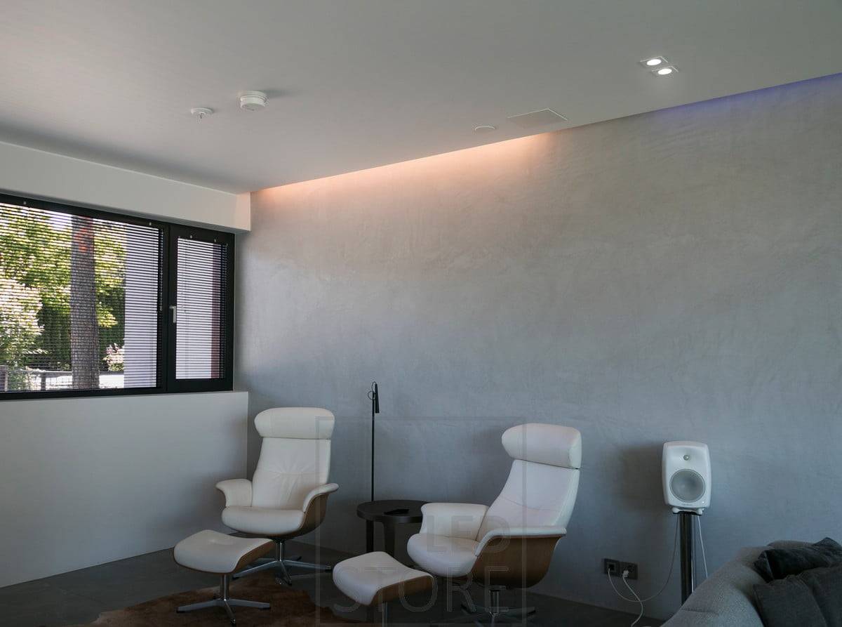 En el salón, iluminación indirecta entre techo y pared combinada con focos. Ledstore.fi