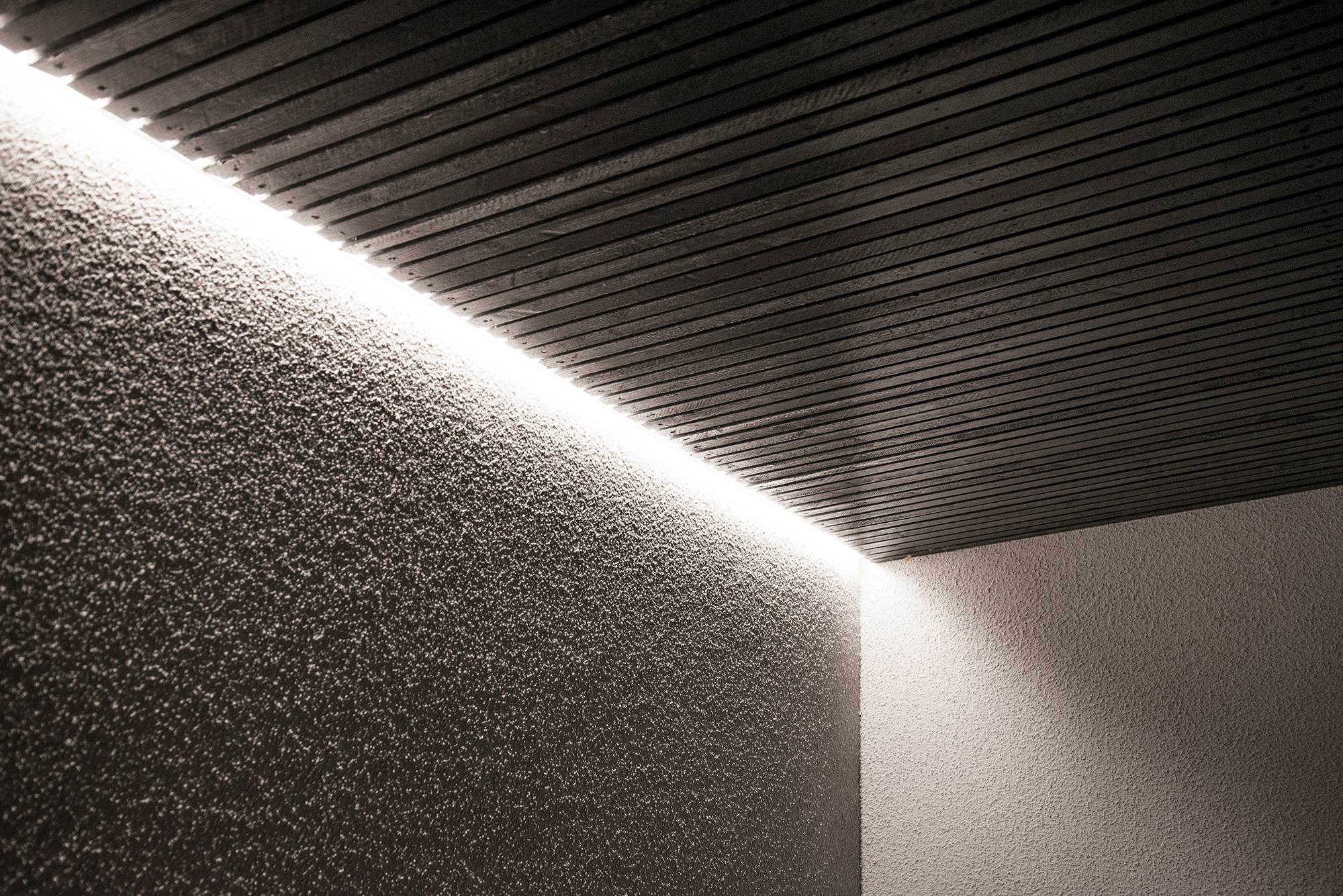Luz indirecta en la fachada de una casa entre el tejado y la pared, iluminada a través de la pared. Ledstore.fi
