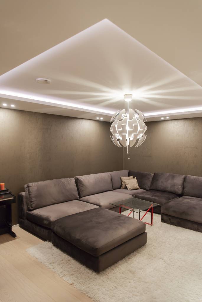 Iluminación indirecta de tira led RGB en una sala de cine circula por la habitación en un clip downlight, color de luz blanco. © LedStore