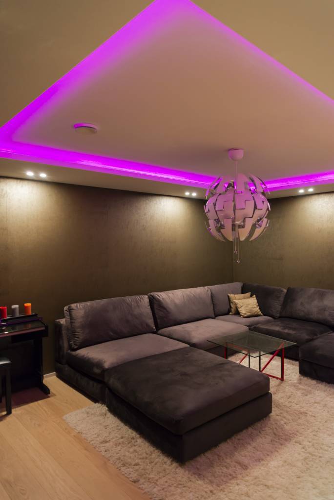 La iluminación indirecta de tira led RGB en una sala de cine circula por la habitación en un clip de iluminación descendente. © LedStore