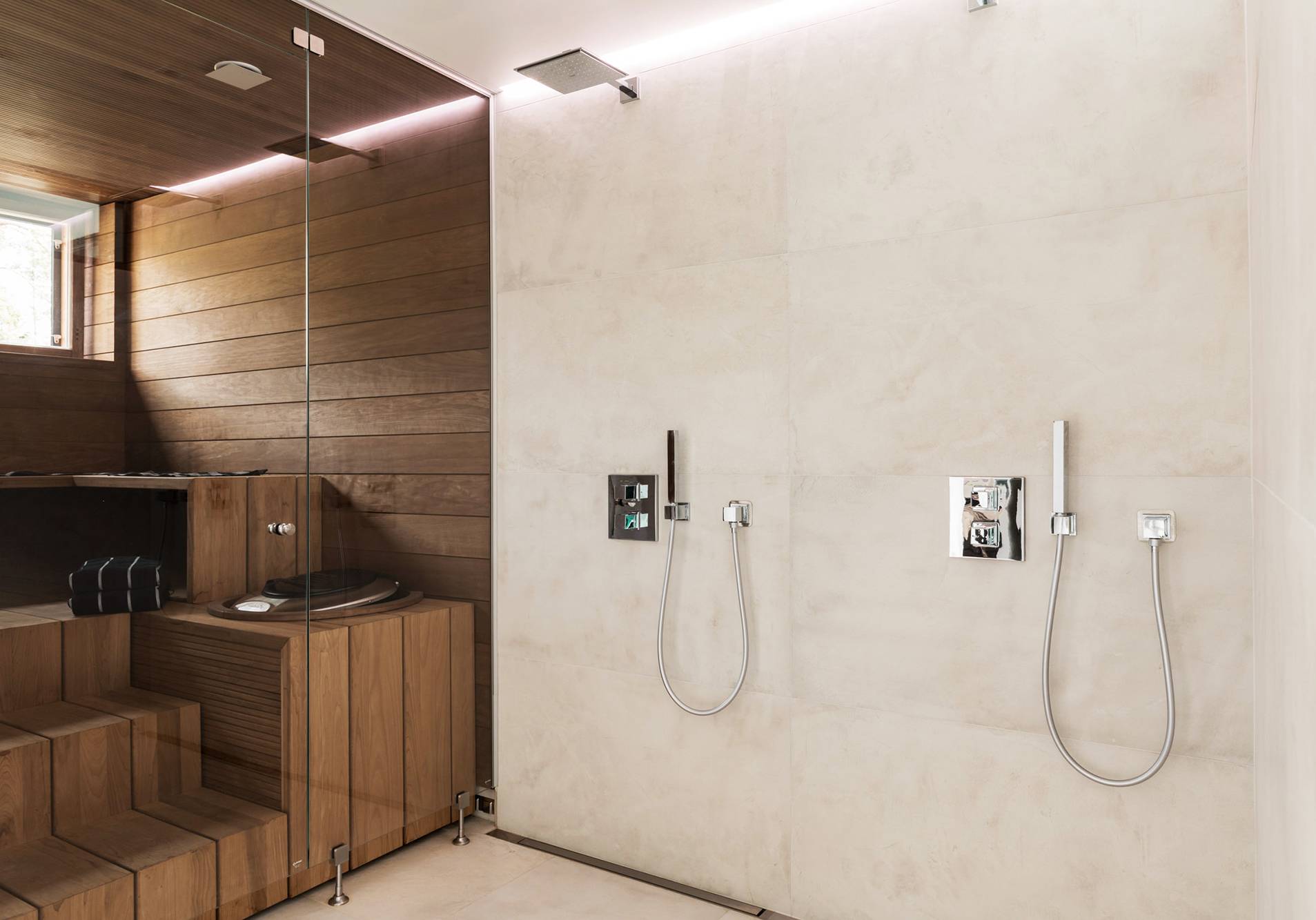 Luz indirecta detrás de la ducha en el baño. Tira led en perfil estanco entre techo y pared en una ranura. Ledstore.fi