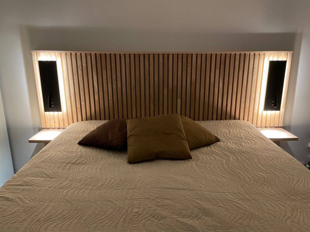 Apliques negros NIGHT en la cabecera de la cama. Tiene una luz de lectura direccional y una luz de ambiente indirecta. Ledstore.fi