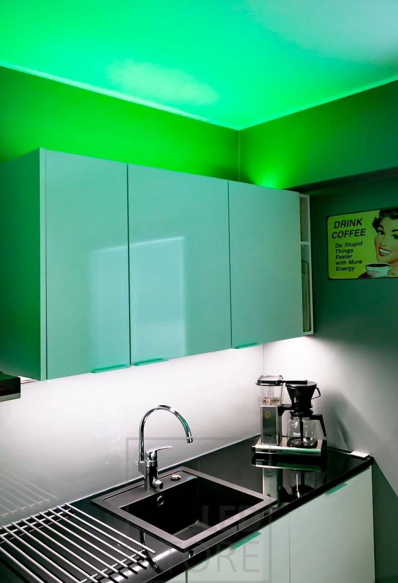 Iluminación ambiental versátil RGB+W con tira de leds, creada para la cocina, tira de leds en un perfil de superficie baja encima de los armarios. La luz también está disponible en blanco 4000K si se desea una iluminación ambiental más neutra. La encimera está iluminada por una tira de leds monocromática. Ledstore.fi