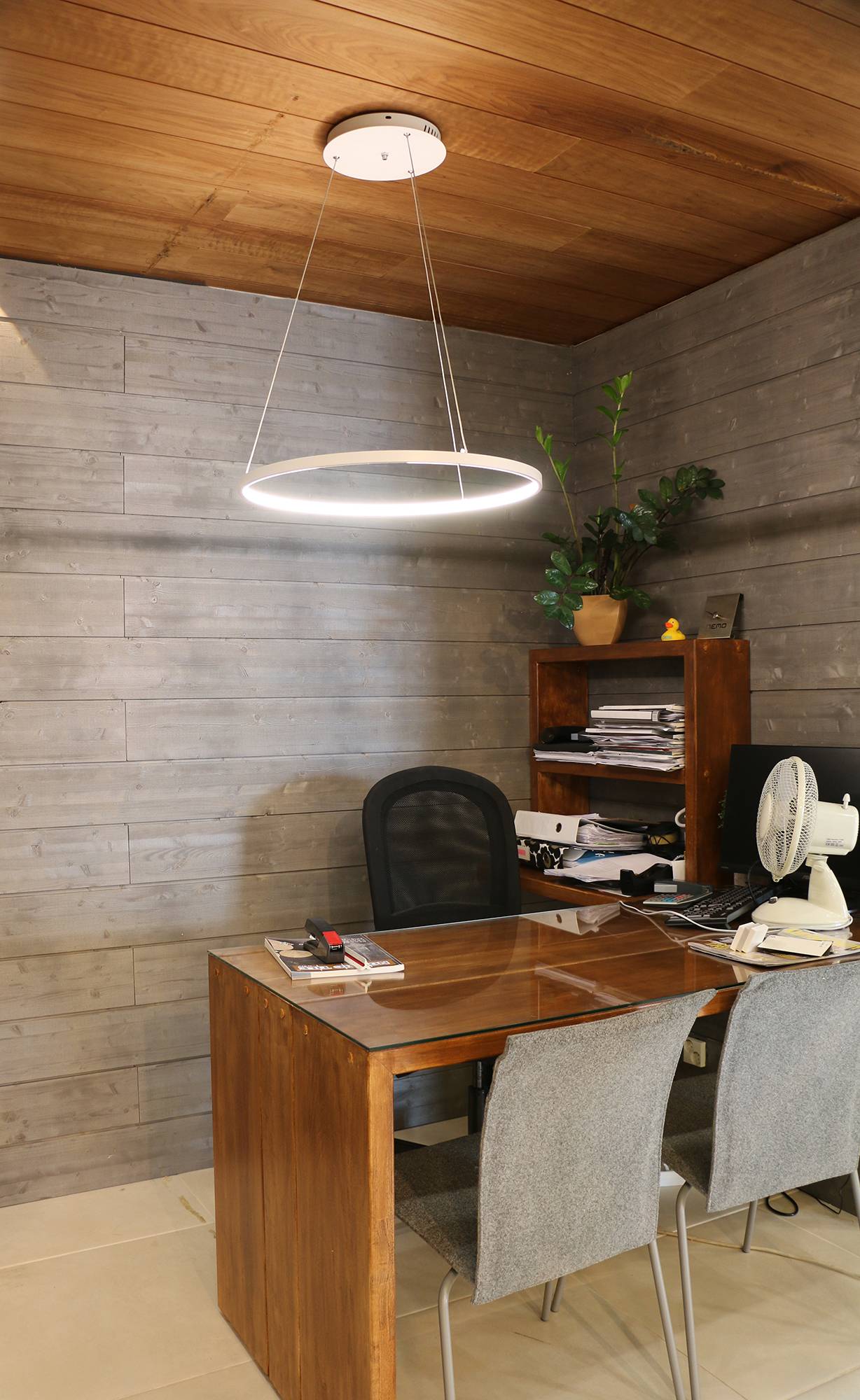 Lámpara Rinkeli sobre el escritorio en el estudio. Led RINKELI CCT es una luminaria minimalista y elegante adecuada no sólo para viviendas sino también para oficinas. La altura de la luminaria desde el techo puede ajustarse entre 20 cm y 250 cm. Ledstore.fi