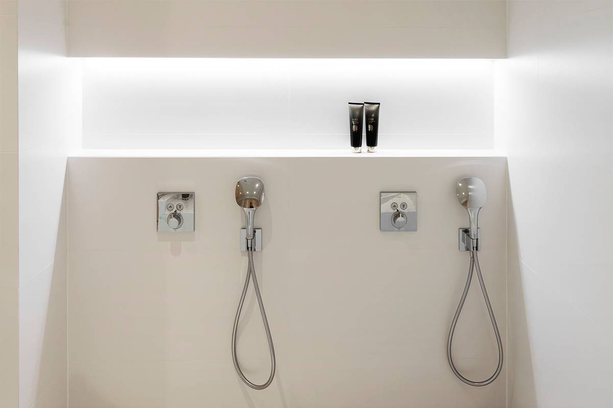 Estante para champú de baño con tira led en la esquina superior iluminando el estante. Ledstore.fi