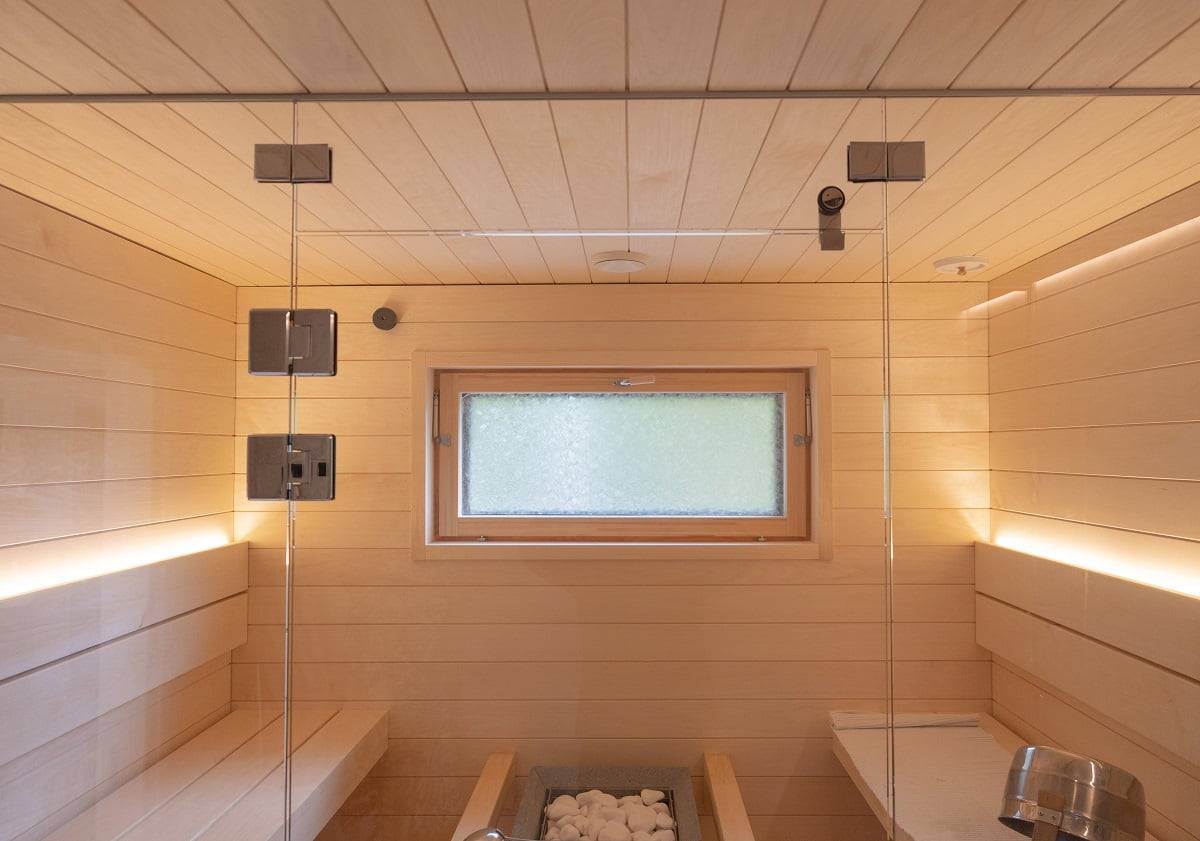 Sauna con tiras de luces led en el respaldo que iluminan hacia arriba. Dos tiras de LED son suficientes para la iluminación de la sauna cuando se permite que la luz se abra.