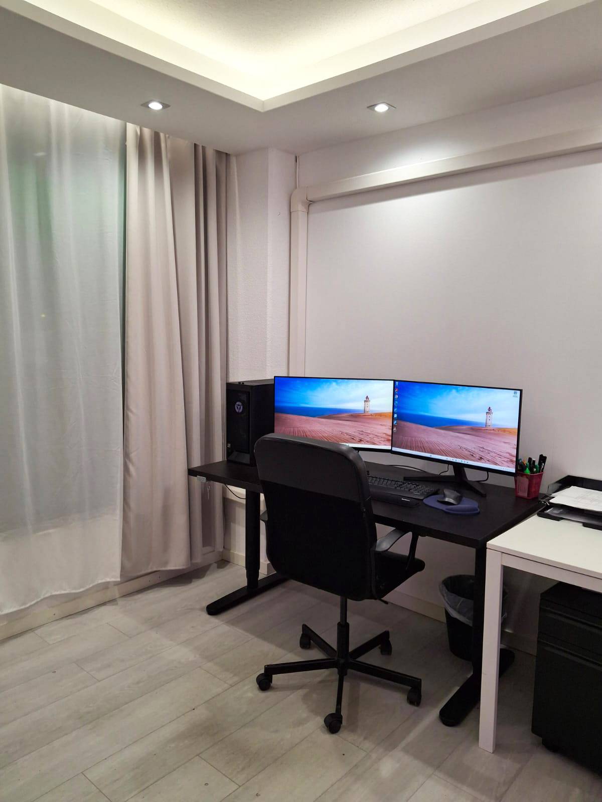 Estudio con mesa de ordenador y silla de escritorio, techo abatible. Focos y luz indirecta de tiras led instaladas en el techo inferior.