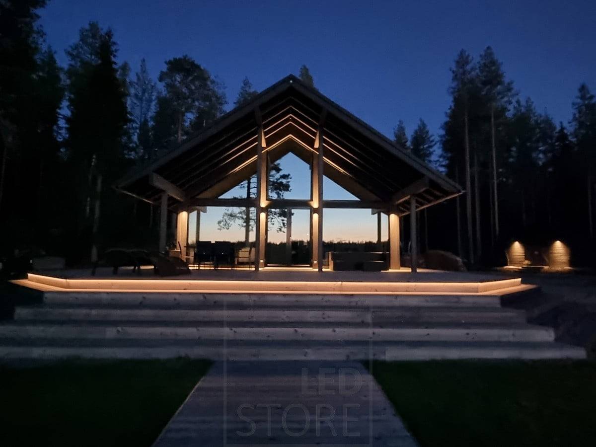 Iluminación exterior versátil con tira de LED en la escalera y apliques de pared. Apliques que iluminan en dos direcciones en un punto alto y en una dirección en un punto más bajo. Ledstore.fi