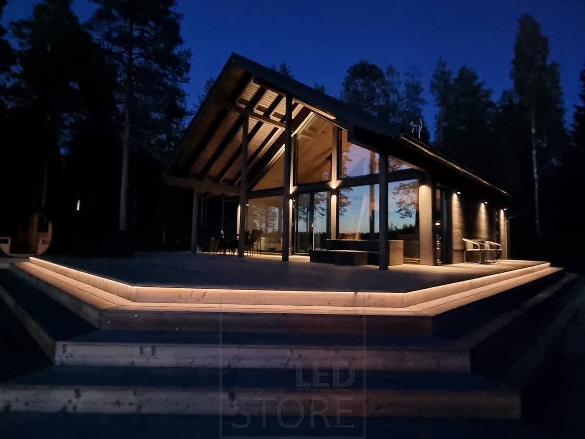 Iluminación exterior versátil con tira de LED en la escalera y apliques de pared. Apliques que iluminan en dos direcciones en un punto alto y en una dirección en un punto más bajo. Ledstore.fi