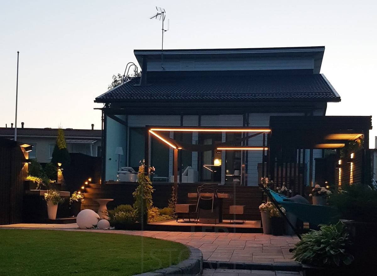 Cinta de led alrededor de la zona de comedor, otras luces de exterior son apliques de pared y bolardos, creando un conjunto versátil. Ledstore.fi
